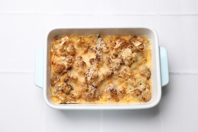 Photo of Tasty baked cauliflower on white tiled table, top view