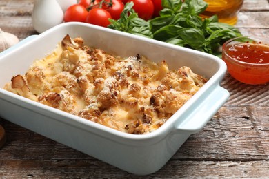 Photo of Tasty baked cauliflower on wooden table, closeup