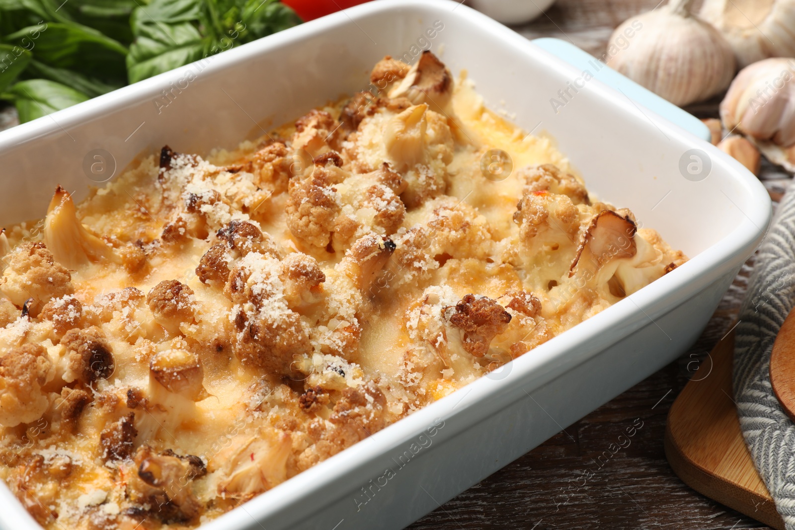 Photo of Tasty baked cauliflower on wooden table, closeup