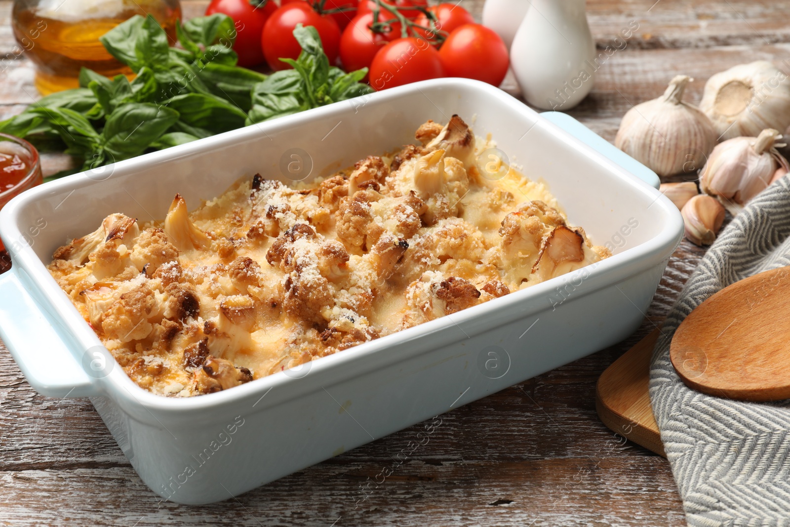 Photo of Tasty baked cauliflower on wooden table, closeup