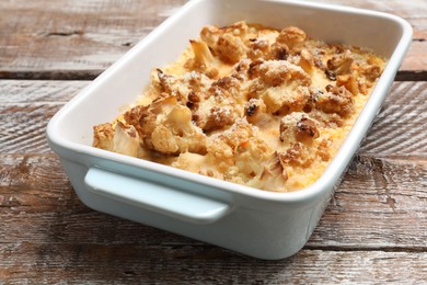 Tasty baked cauliflower on wooden table, closeup