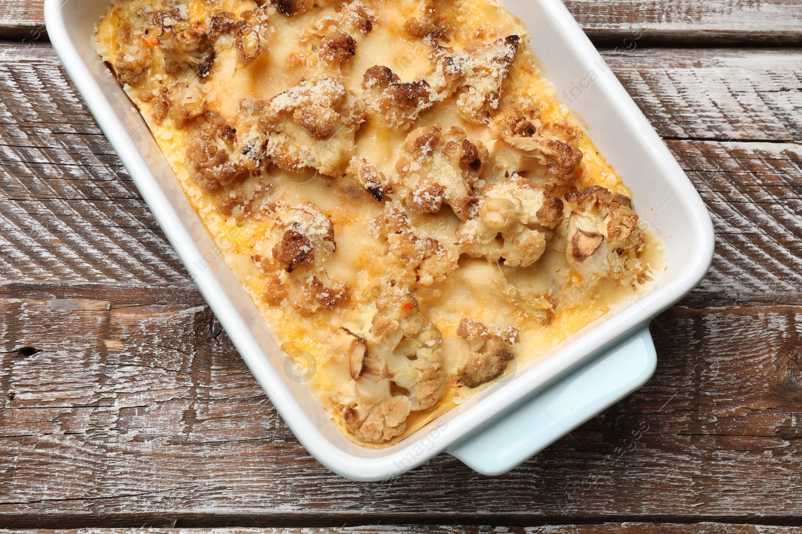 Photo of Tasty baked cauliflower on wooden table, top view