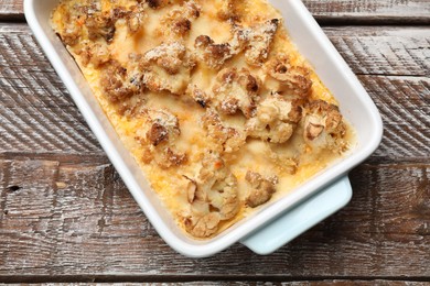 Photo of Tasty baked cauliflower on wooden table, top view