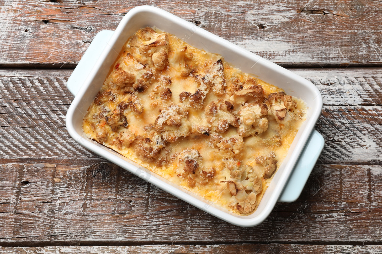 Photo of Tasty baked cauliflower on wooden table, top view