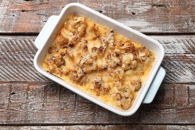 Tasty baked cauliflower on wooden table, top view