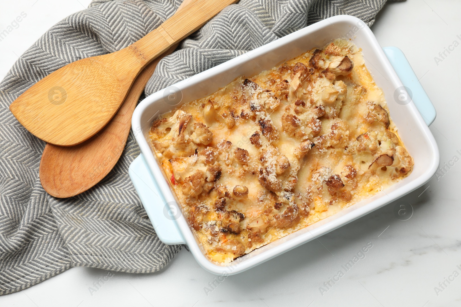 Photo of Tasty baked cauliflower in baking dish on white marble table, top view