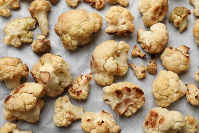 Tasty baked cauliflower on parchment, flat lay