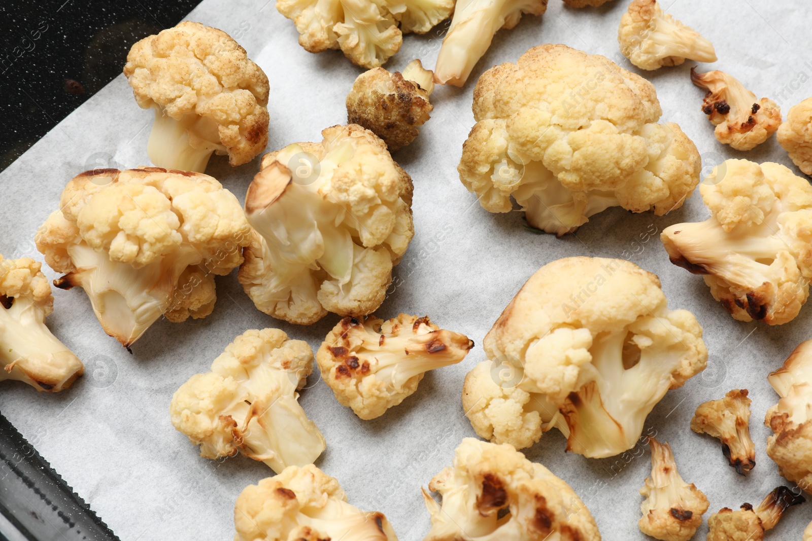 Photo of Tasty baked cauliflower on baking tray, top view