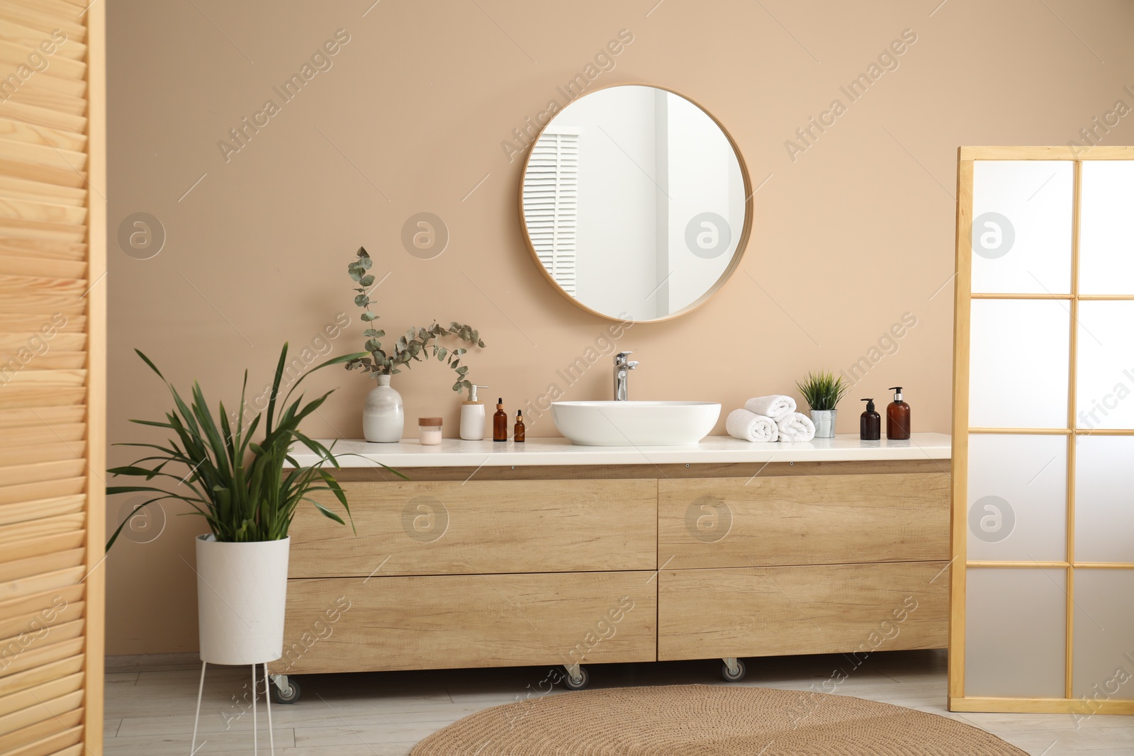 Photo of Folding screen, vanity, sink, mirror and floral decor in bathroom. Interior design