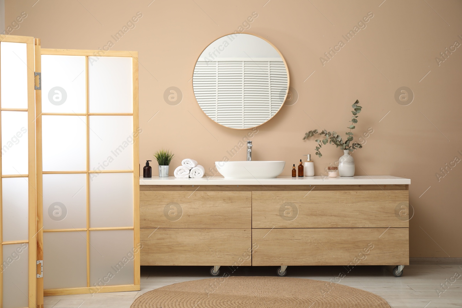 Photo of Folding screen, vanity, sink, mirror and floral decor in bathroom. Interior design