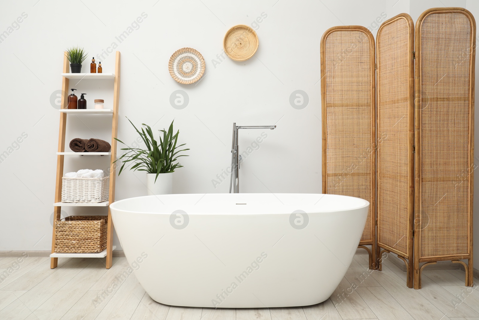 Photo of Stylish bathroom interior with folding screen and tub