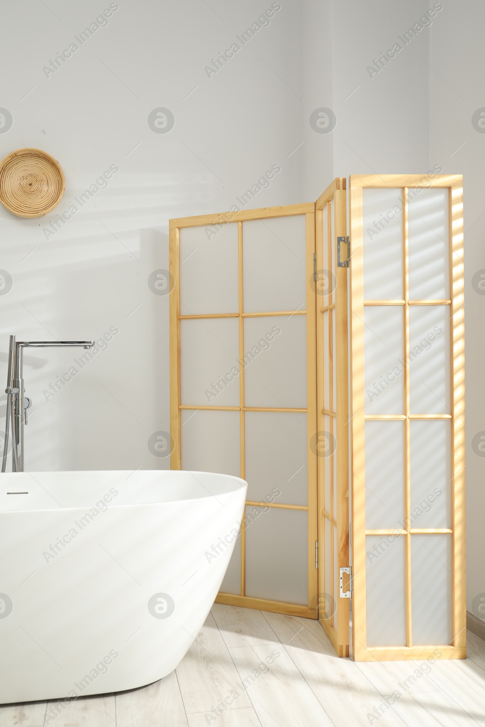 Photo of Folding screen and tub in bathroom. Interior design