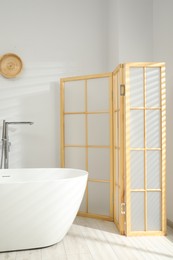 Photo of Folding screen and tub in bathroom. Interior design