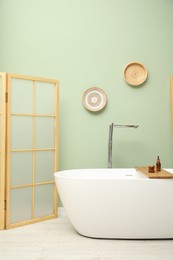 Stylish bathroom interior with folding screen and tub