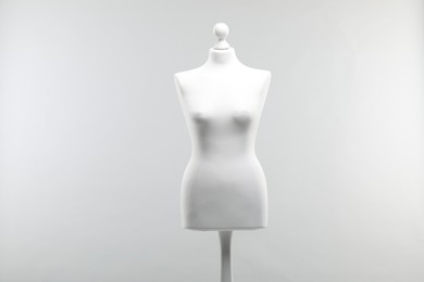 Photo of One mannequin on light grey background. Fashion designer`s equipment