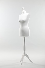 Photo of One mannequin on light grey background. Fashion designer`s equipment