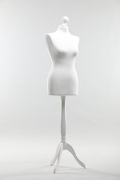 Photo of One mannequin on light grey background. Fashion designer`s equipment