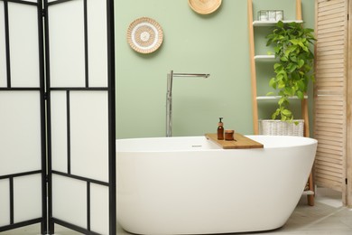 Stylish bathroom interior with folding screen and tub