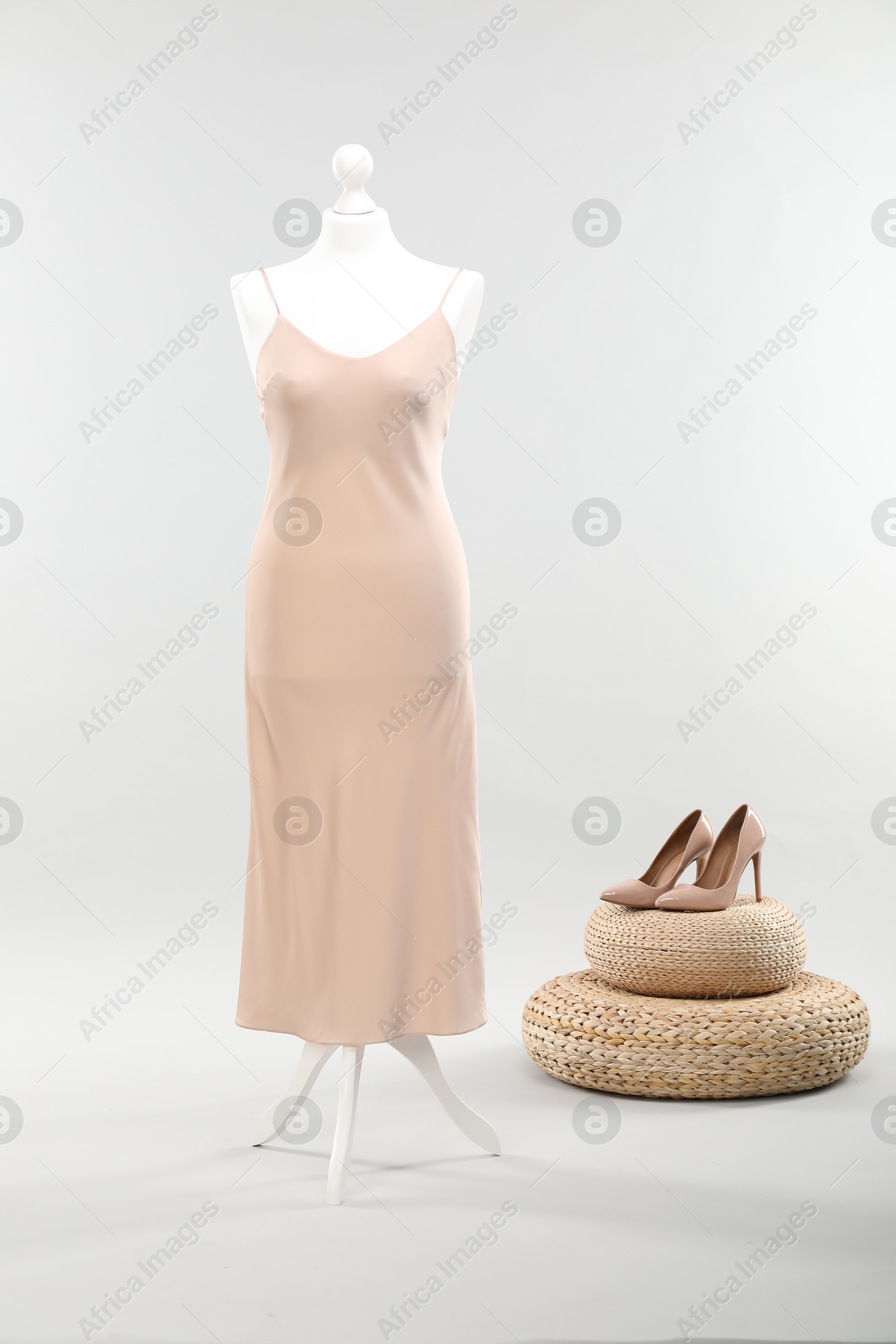 Photo of Mannequin with new stylish dress and high heels on light grey background