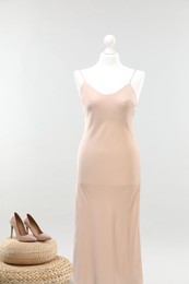 Photo of Mannequin with new stylish dress and high heels on light grey background