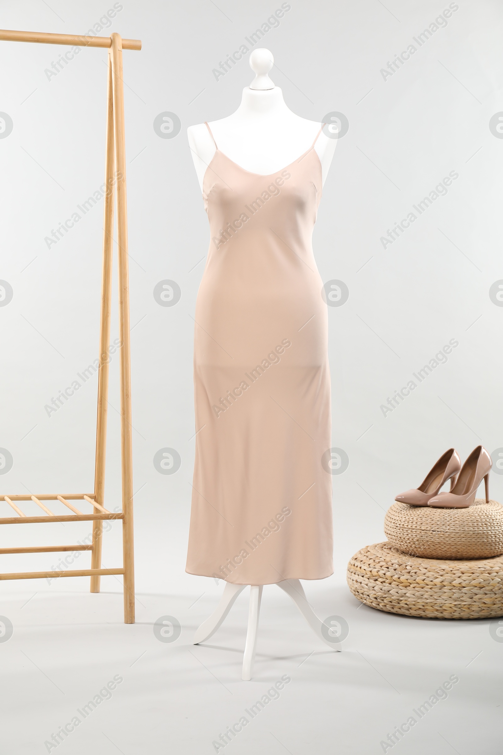 Photo of Mannequin with new stylish dress and high heels on light grey background