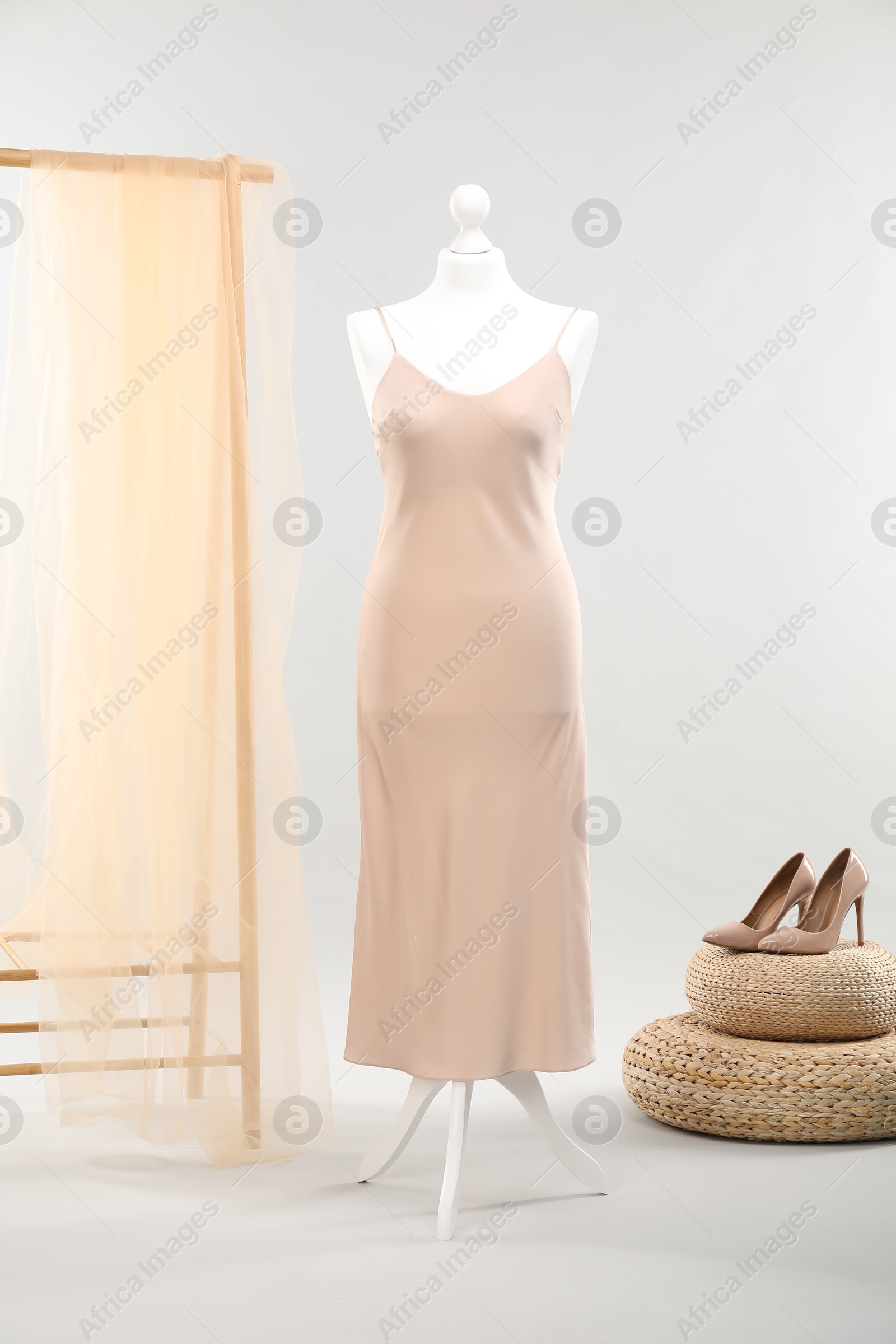 Photo of Mannequin with new stylish dress and high heels on light grey background