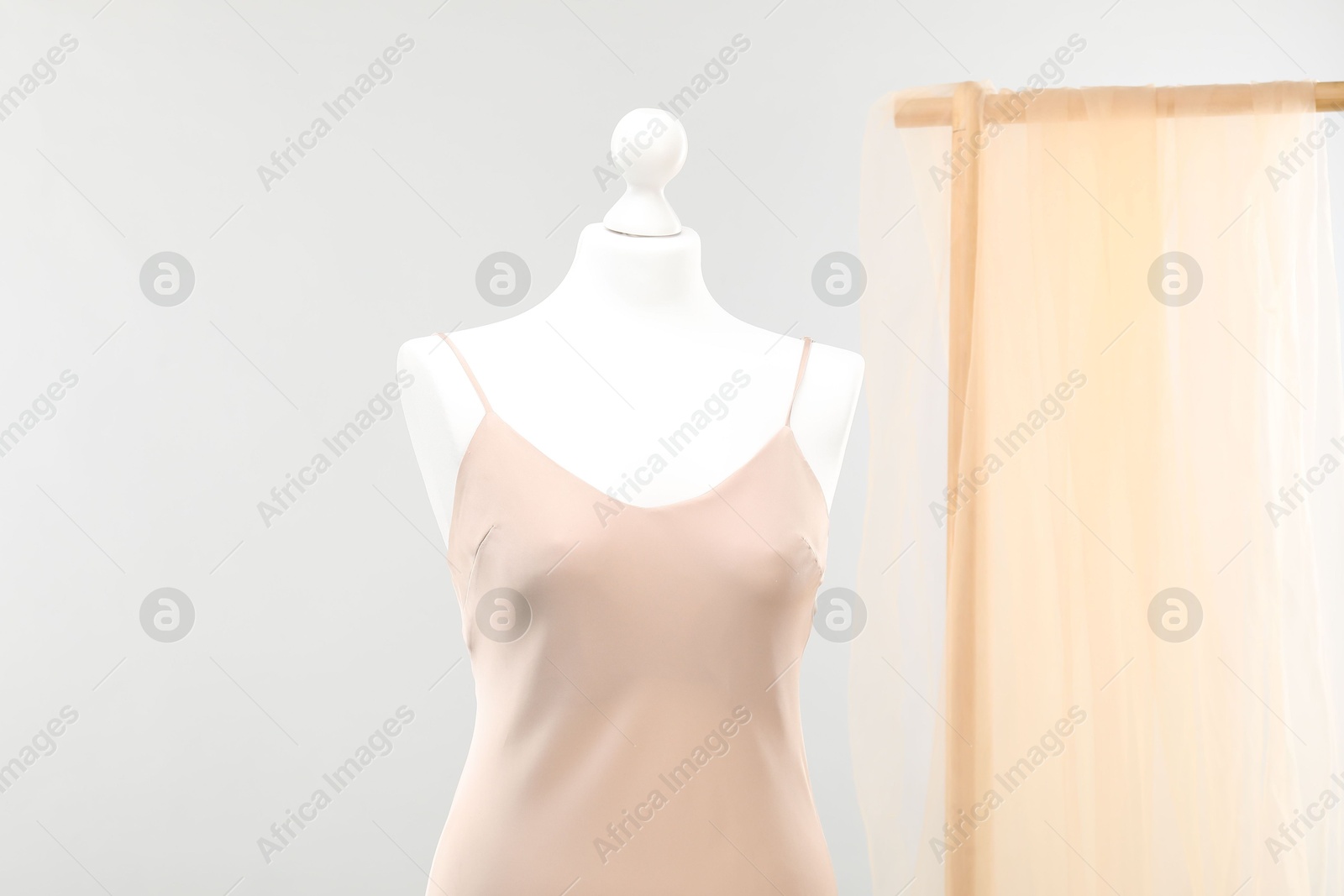 Photo of Mannequin with new stylish dress against light grey background