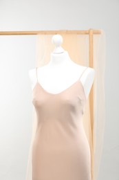 Mannequin with new stylish dress against light grey background