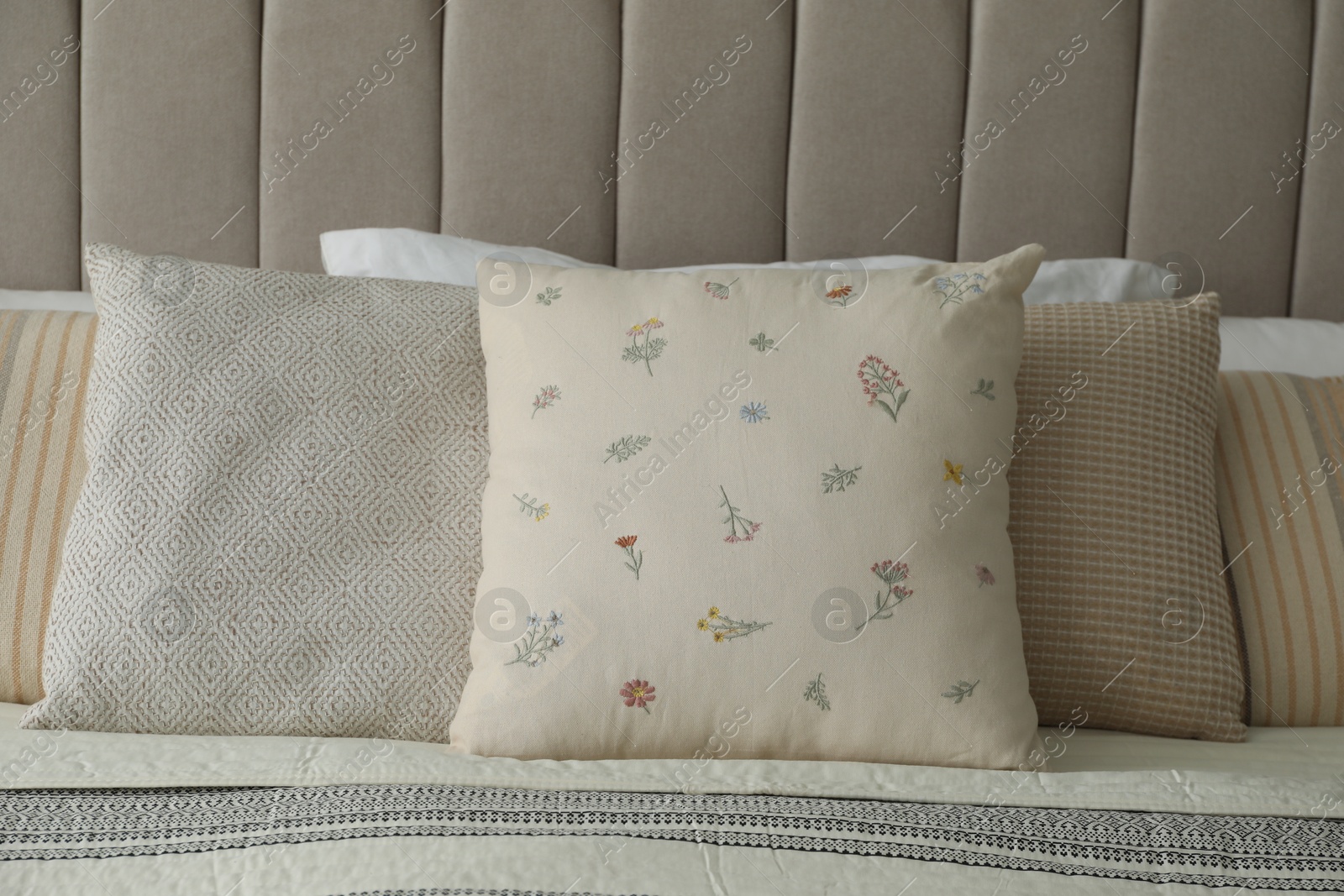 Photo of Different color pillows on bed in bedroom, closeup