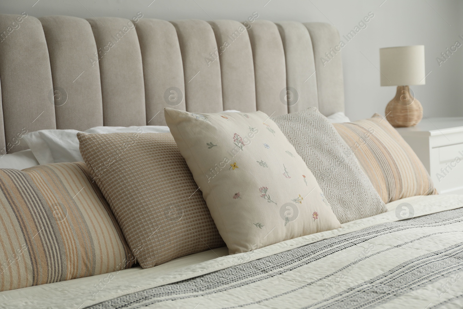 Photo of Different color pillows on bed in bedroom, closeup