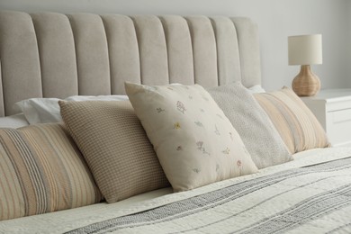 Different color pillows on bed in bedroom, closeup