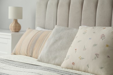 Different color pillows on bed in bedroom, closeup