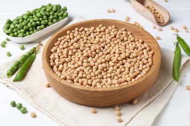 Photo of Dried peas and pods with fresh ones on white wooden table, closeup