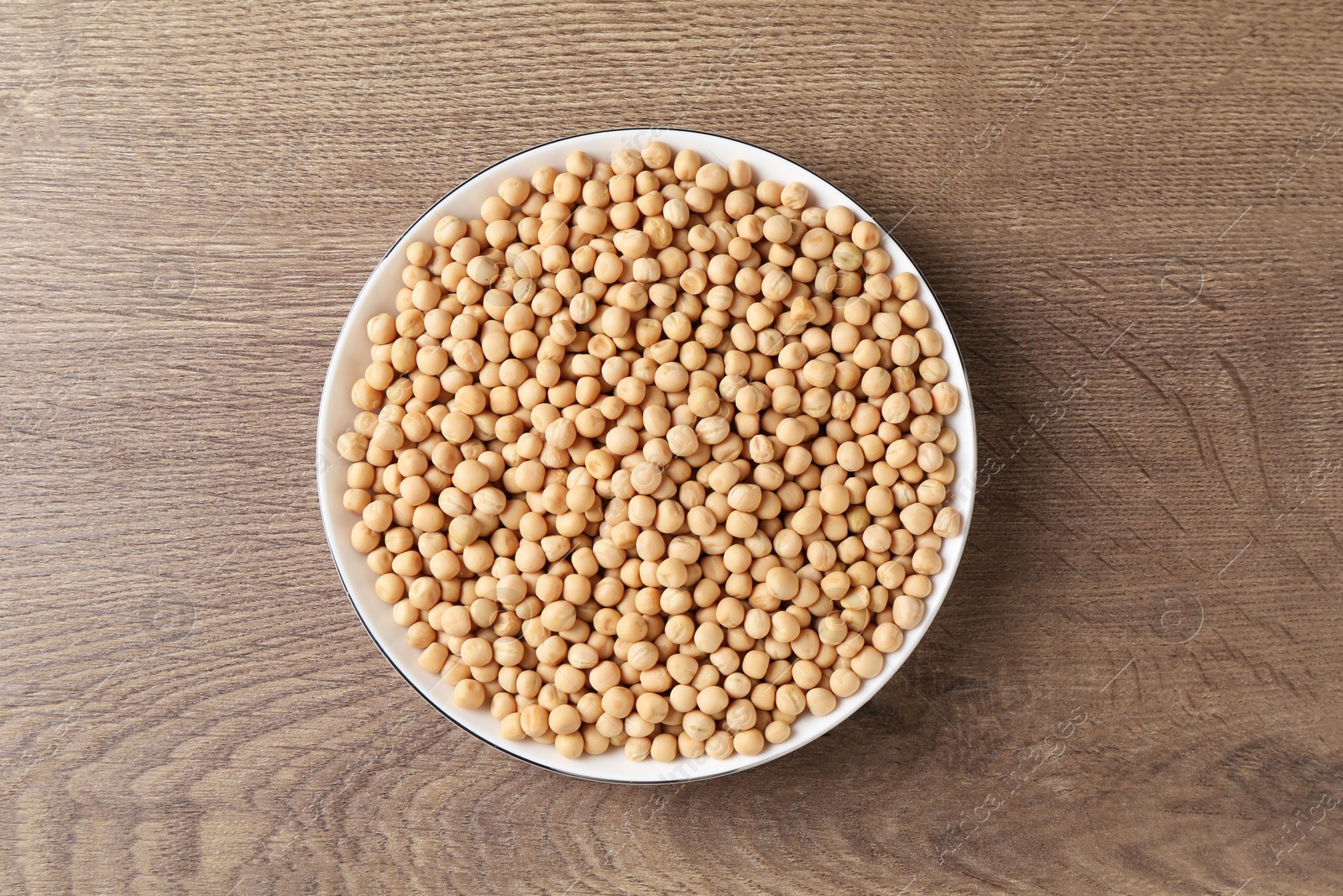 Photo of Dried peas on wooden table, top view