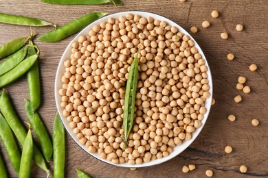 Dried peas and pods with fresh ones on wooden table, flat lay