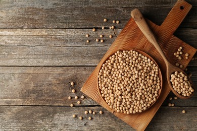 Dried peas, plate, board and spoon on wooden table, top view. Space for text