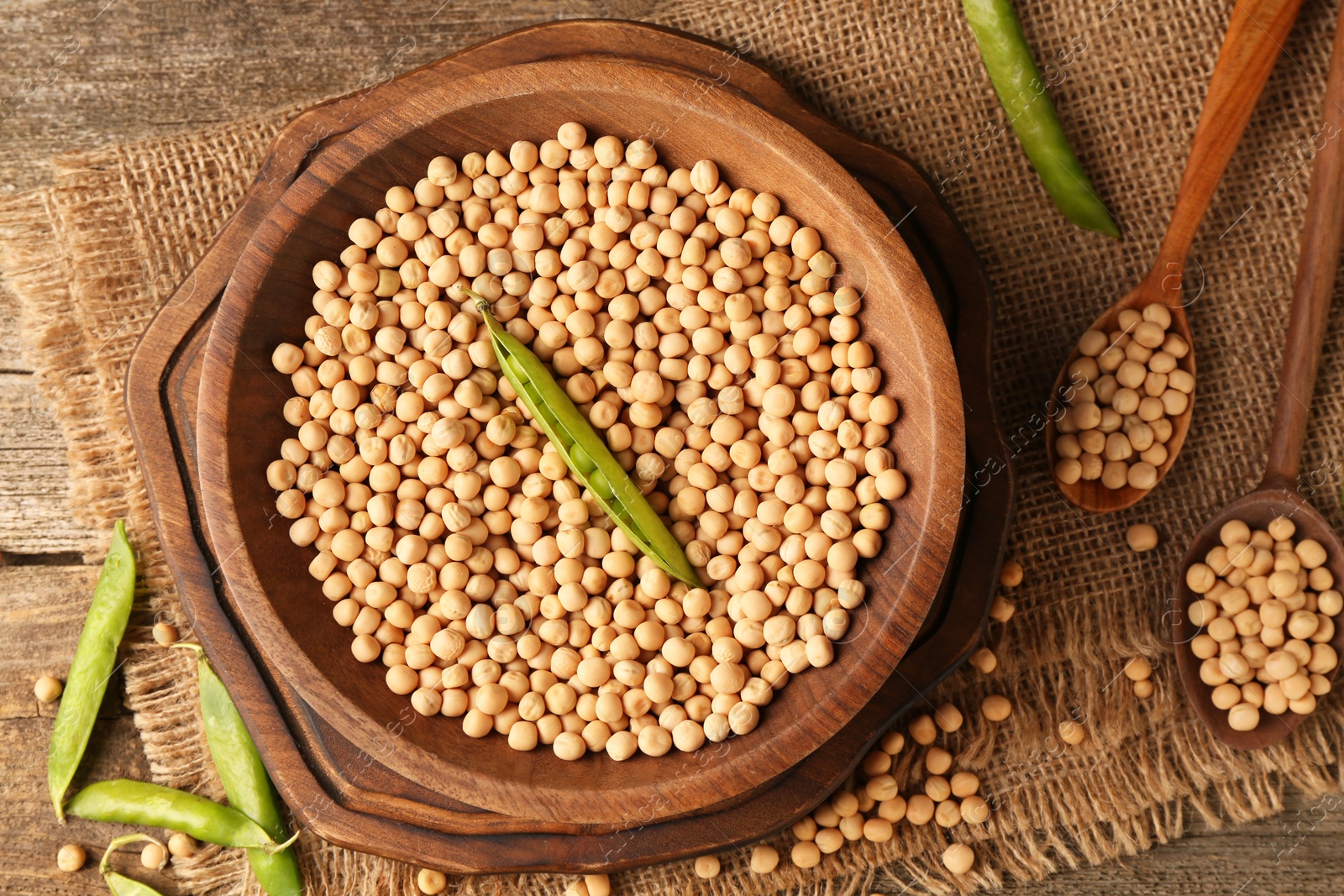 Photo of Fresh pods with peas and dried ones on wooden table, top view