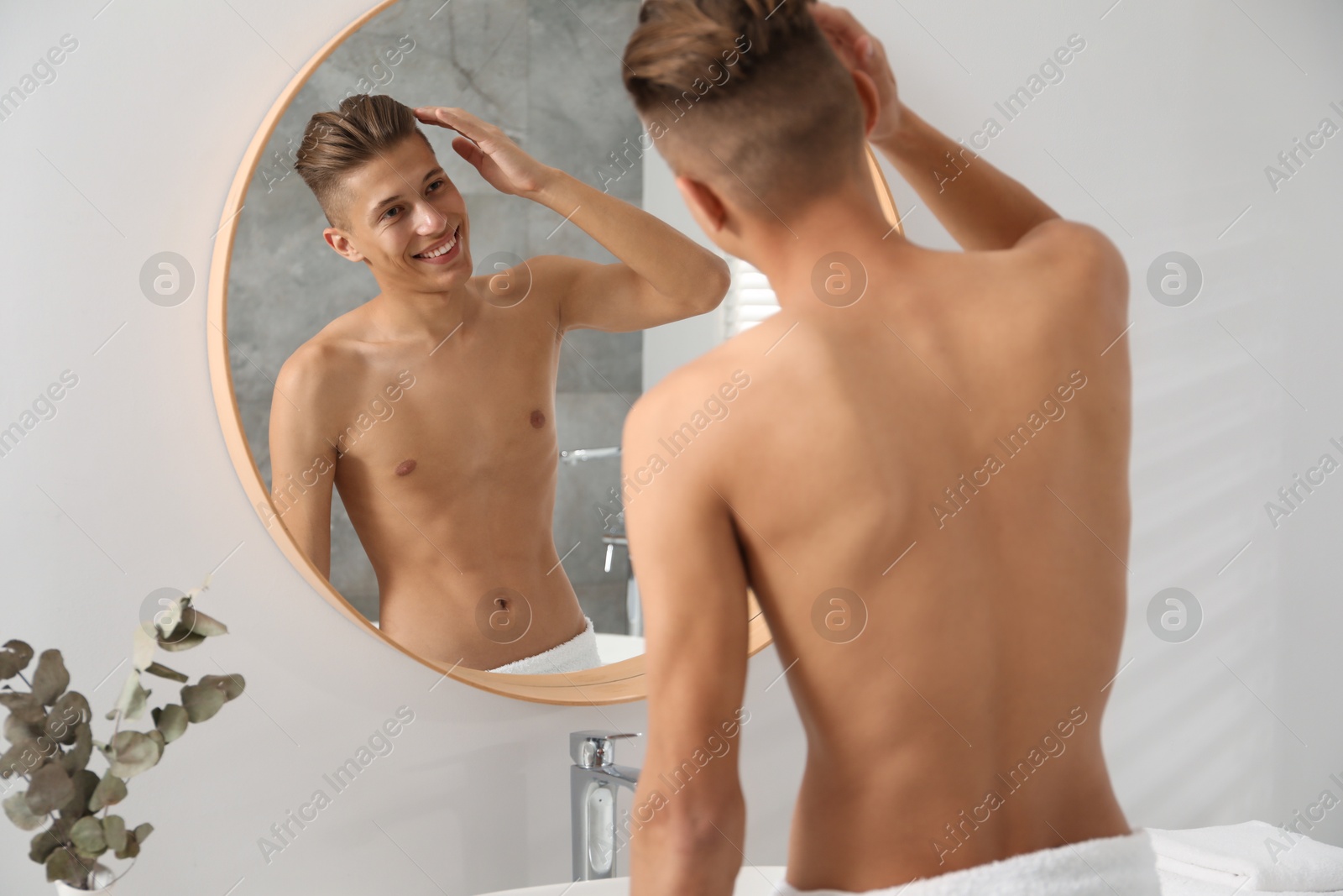 Photo of Handsome man looking at mirror in bathroom