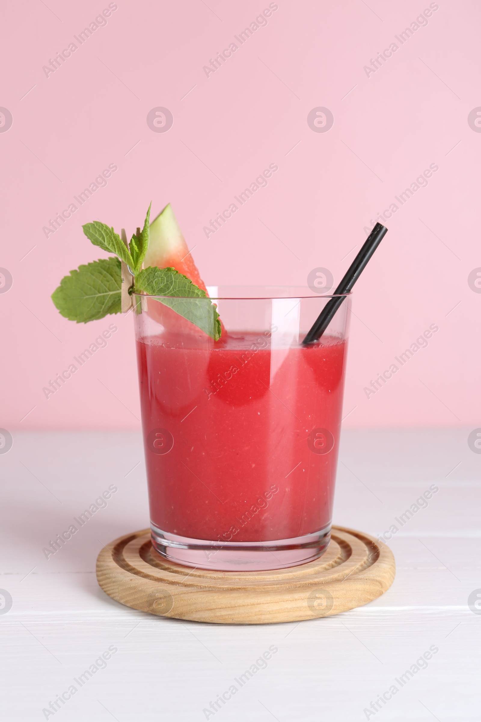 Photo of Tasty watermelon drink in glass and mint on white wooden table