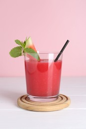 Photo of Tasty watermelon drink in glass and mint on white wooden table