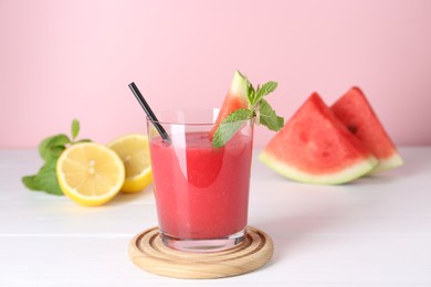 Photo of Tasty watermelon drink in glass, mint and fresh fruits on white wooden table