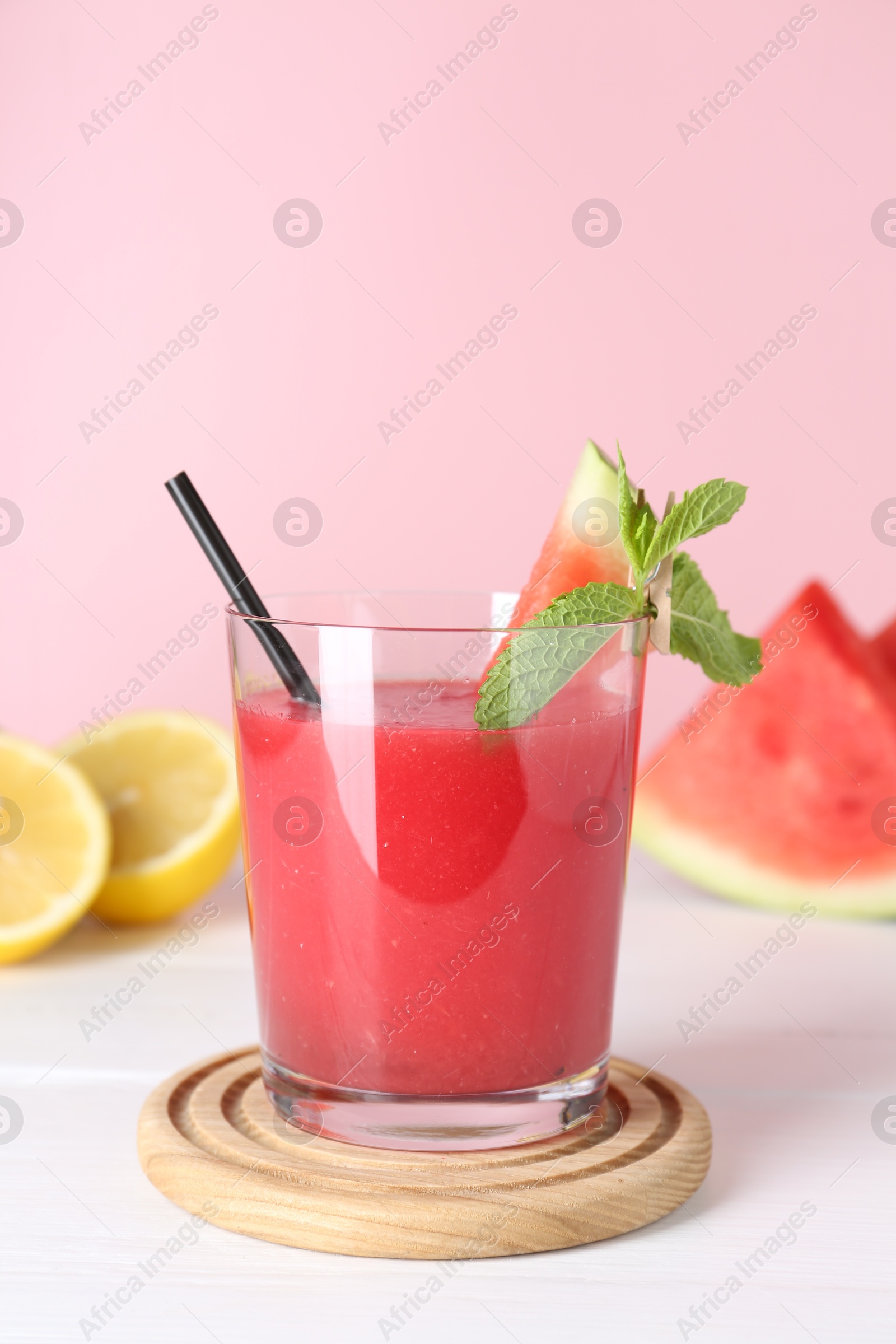 Photo of Tasty watermelon drink in glass, mint and fresh fruits on white wooden table