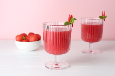 Photo of Tasty watermelon drink in glasses and fresh fruit on white wooden table