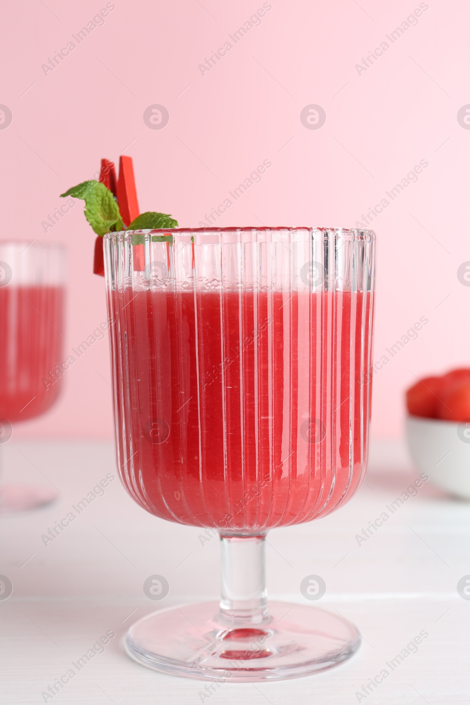 Photo of Tasty watermelon drink in glass and mint on white wooden table, closeup