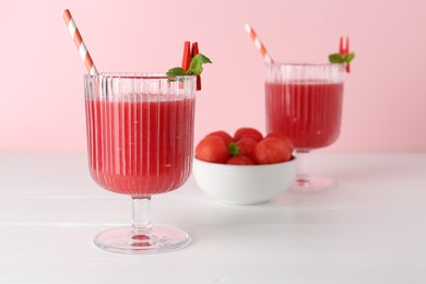 Photo of Tasty watermelon drink in glasses and fresh fruit on white wooden table