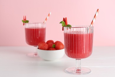 Photo of Tasty watermelon drink in glasses and fresh fruit on white wooden table