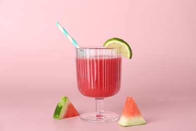 Photo of Tasty watermelon drink in glass and fresh fruits on pink background