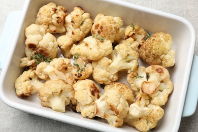 Photo of Baked cauliflower in baking dish on light grey table, top view