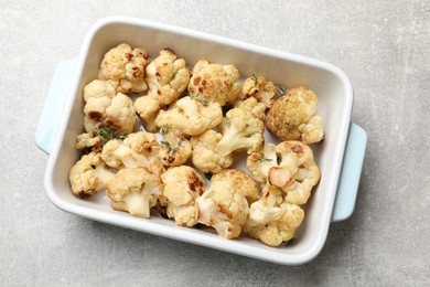 Baked cauliflower in baking dish on light grey table, top view