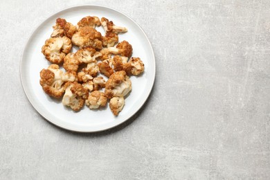 Photo of Baked cauliflower on light grey table, top view. Space for text